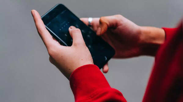 Person using both hands and thumbs to type on phone.